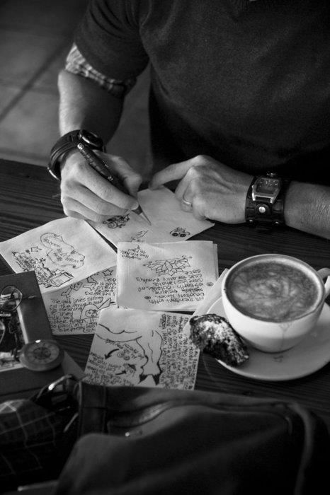 a person sitting at a table with papers and a cup of coffee