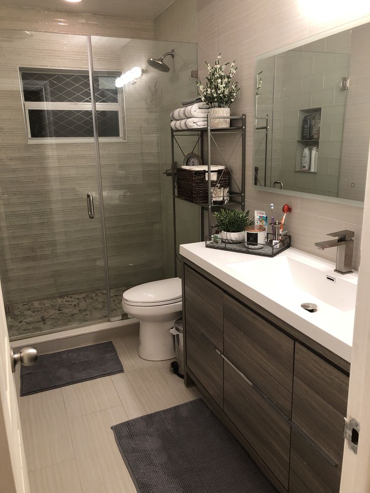 a bathroom with a sink, toilet and shower stall in the middle of the room