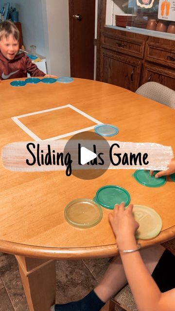 two children sitting at a table with plates on it and the words sliding las game in front of them