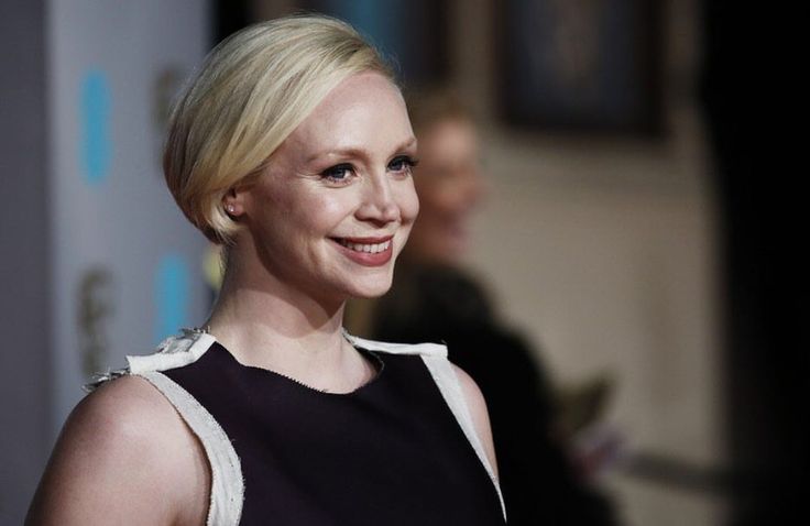 a close up of a person wearing a black and white dress smiling at the camera