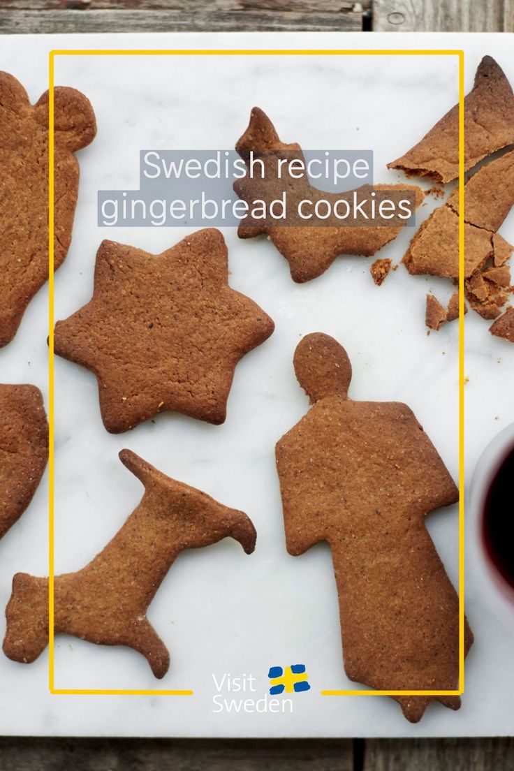 some cut out gingerbread cookies are on a white plate next to a cup of coffee