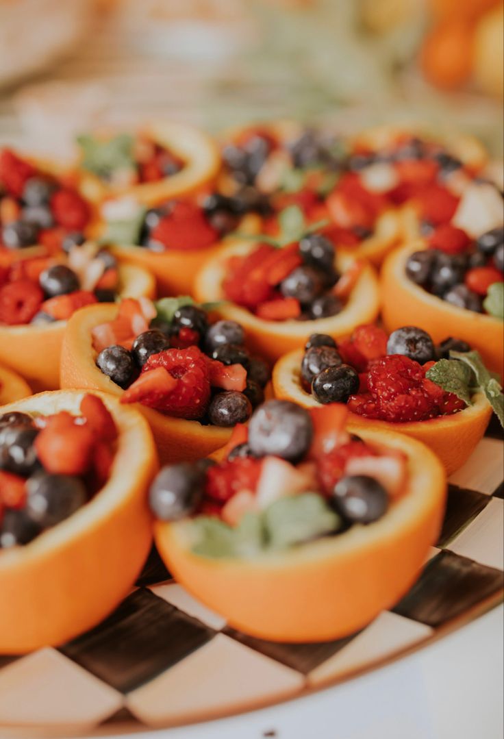 small orange cups filled with fruit on top of a checkered plate