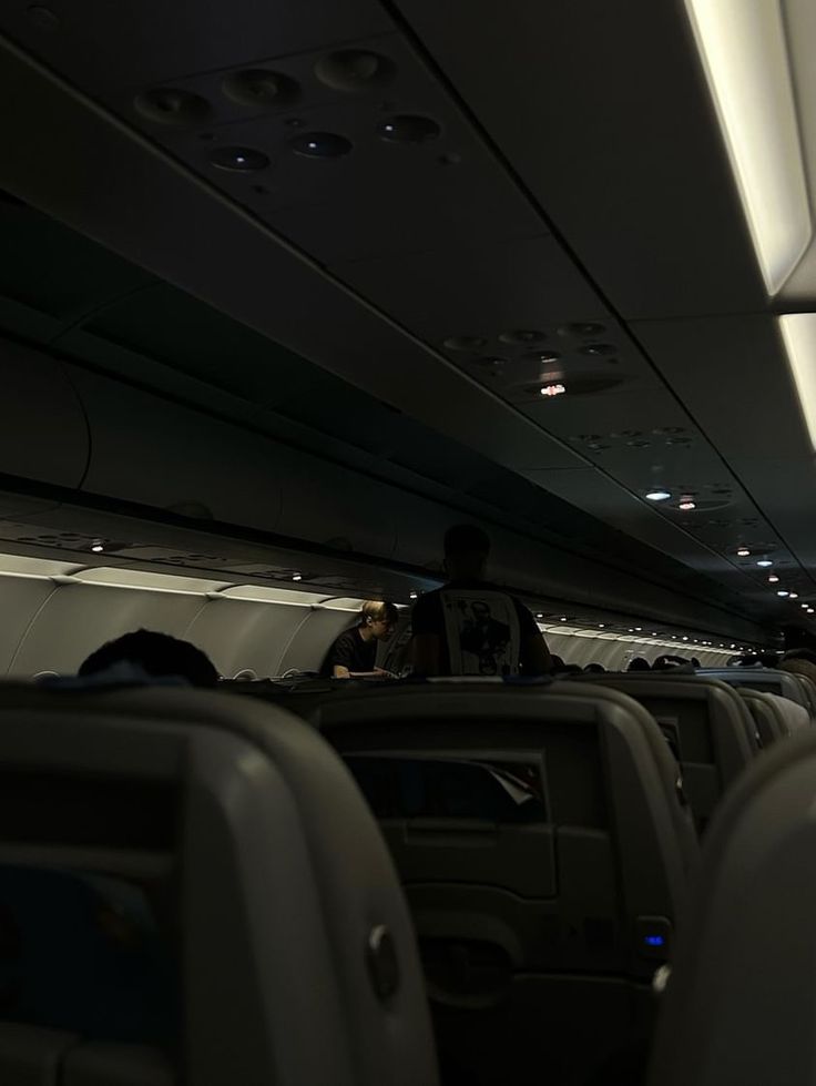 the inside of an airplane with people sitting on seats