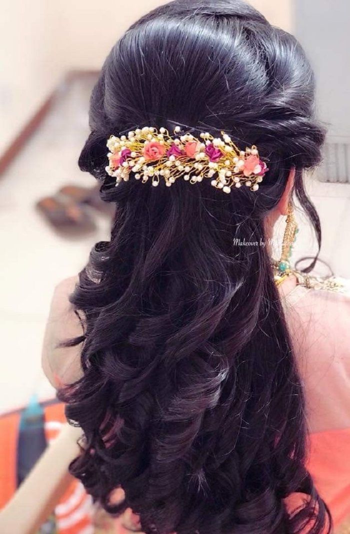 the back of a woman's head wearing a hair comb with flowers on it