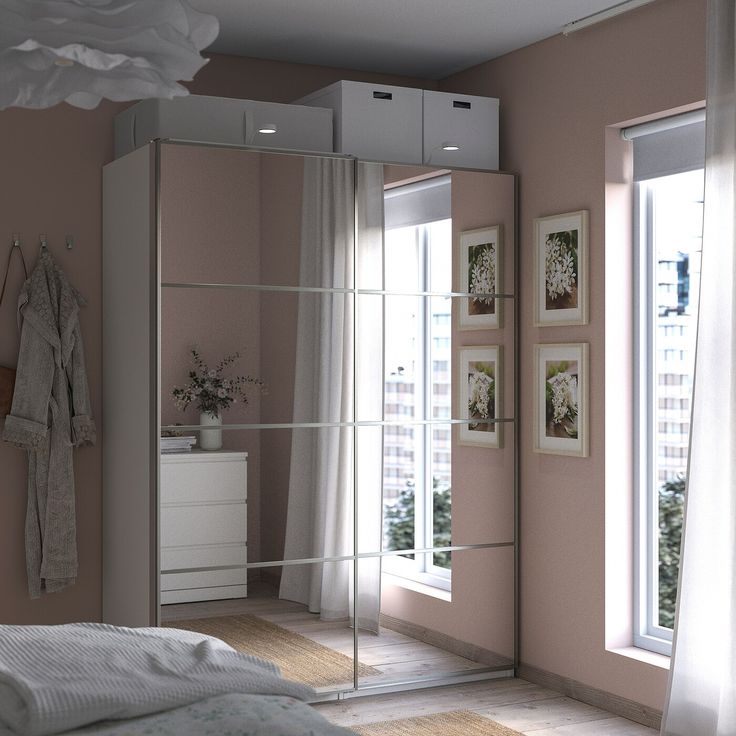 a bedroom with pink walls and white furniture