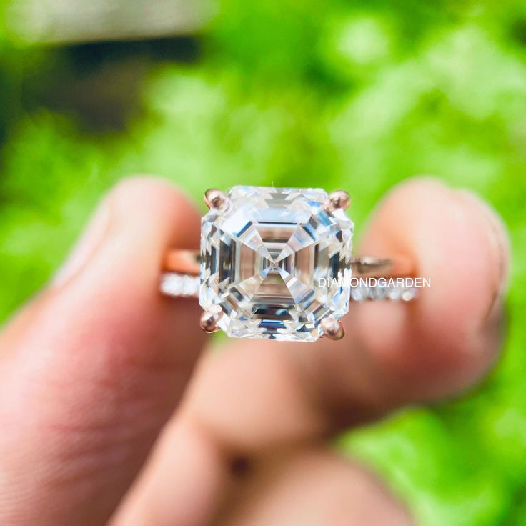 a person holding an engagement ring with a large diamond in it's middle finger