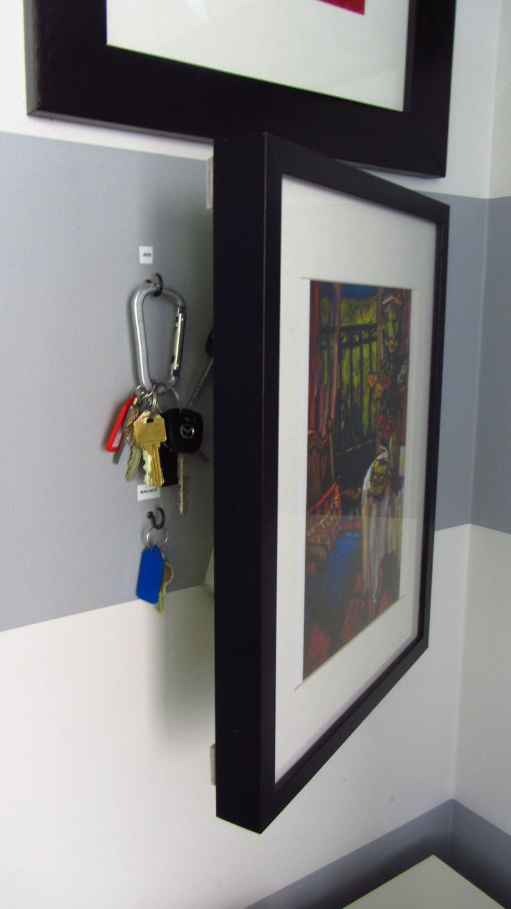 there is a key holder on the wall next to a framed picture with keys in it