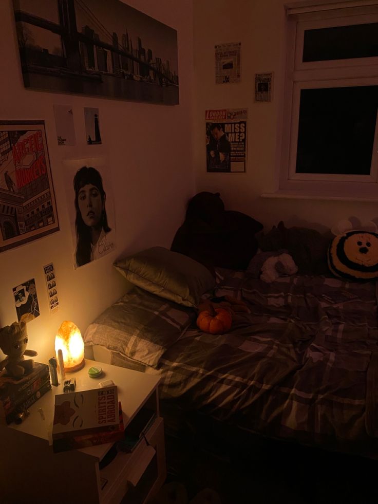 a bed room with a neatly made bed and a lit candle on the night stand