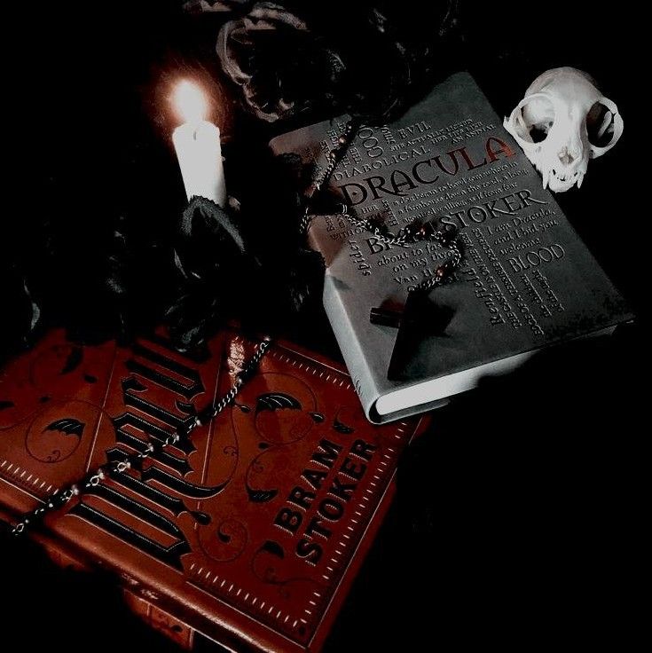 a book with a skull on it next to two candles