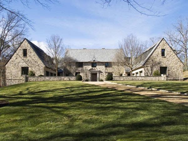 a large stone house sitting on top of a lush green field