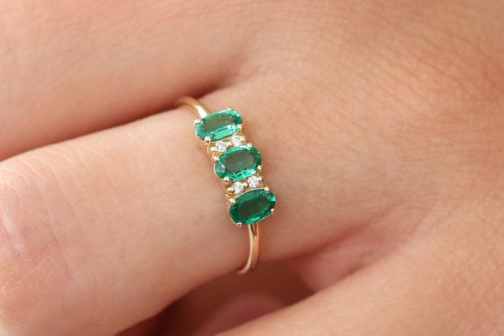 "Oval Emerald Ring / 14k Solid Gold Natural Genuine Emerald and Diamond Ring / Green Gemstone Ring / Green Emerald / Emerald Jewelry Item Details *Made to Order. *Gold Kt: 14K Solid Gold *Custom Gold Color: Rose Gold, Yellow Gold, White Gold *Round Diamond: 4 Pcs 1.20MM *Oval Emerald: 3 Pcs 5x3MM *Total Diamond tTW: 0.05ctw *Total Emerald ctw: 0.65ctw *Diamond Color-Clarity: G Color SI Clarity *Width of Band: 1.3MM *Setting Type: Prong *Ready to Ship in 7-10 Business Days If you have any additio Gold Oval Emerald Ring, Black Diamond Earrings Studs, Moissanite Engagement Ring Rose Gold, Green Gemstone Ring, Black Diamond Earrings, Emerald Rings, Emerald And Diamond Ring, Nature Inspired Rings, Emerald Earrings Studs