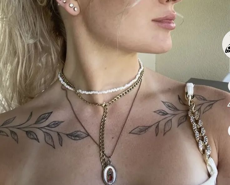 a woman with tattoos on her chest wearing a necklace