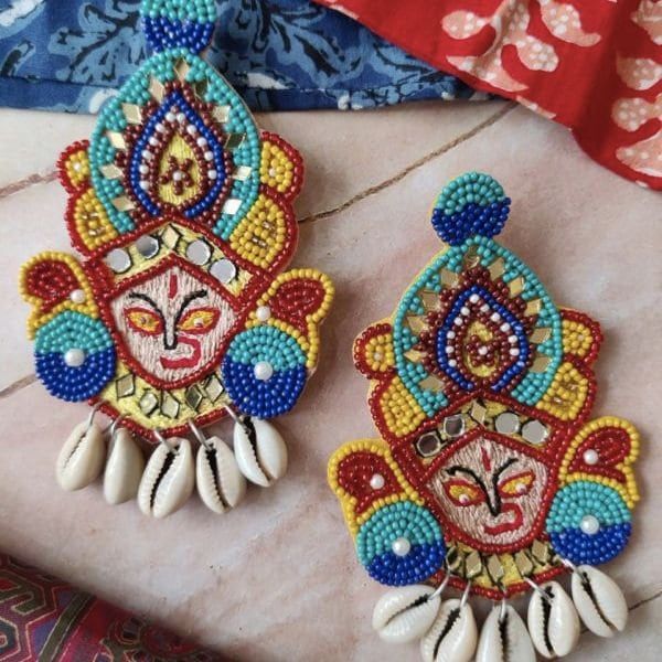 Introducing the stunning Ma Durga , Durga Hand and Kalash Handmade Beaded Earrings, by Town Of Trinkets a perfect addition to your jewelry collection. These earrings feature a colorful combination of beads and shells, creating a unique and eye-catching design. Handmade with care, these earrings are not only beautiful but also durable. The Ma Durga Handmade Beaded Earrings are perfect for any occasion, adding a touch of elegance and style to any outfit. Don't miss out on this one-of-a-kind piece of jewelry. Order yours today! Multicolor Temple Jewelry Earrings For Festival, Artisan Handmade Beads For Festive Occasions, Artisan Handmade Festive Beads, Handmade Multicolor Temple Jewelry Earrings, Multicolor Beaded Temple Jewelry Earrings, Handmade Multicolor Earrings For Beach, Handmade Beaded Earrings As Festival Gifts, Handmade Multicolor Beads For Festive Occasions, Traditional Colorful Beaded Earrings For Beach