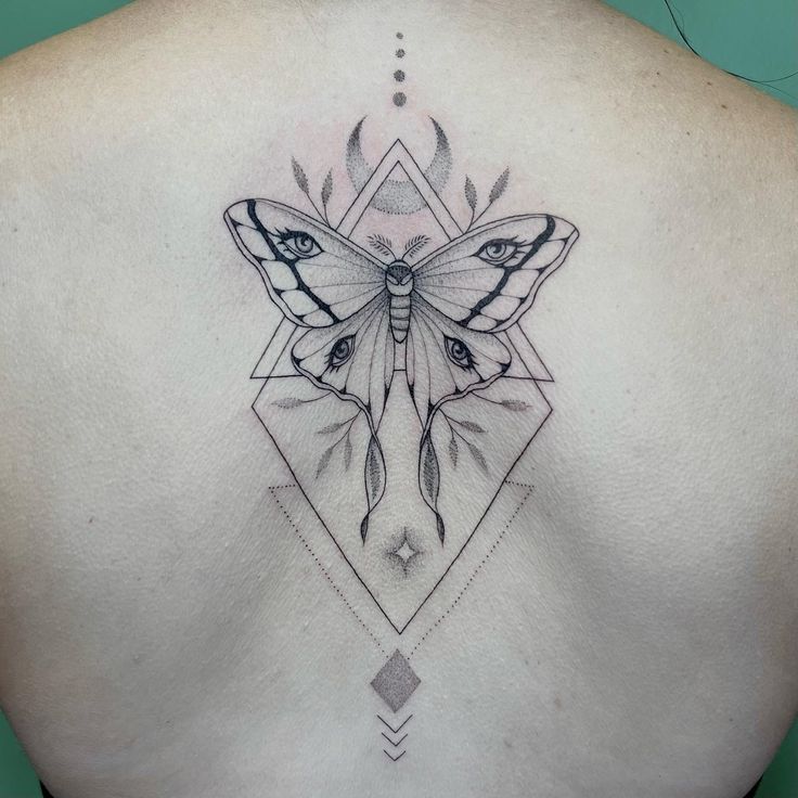 a woman's back with a butterfly tattoo on it