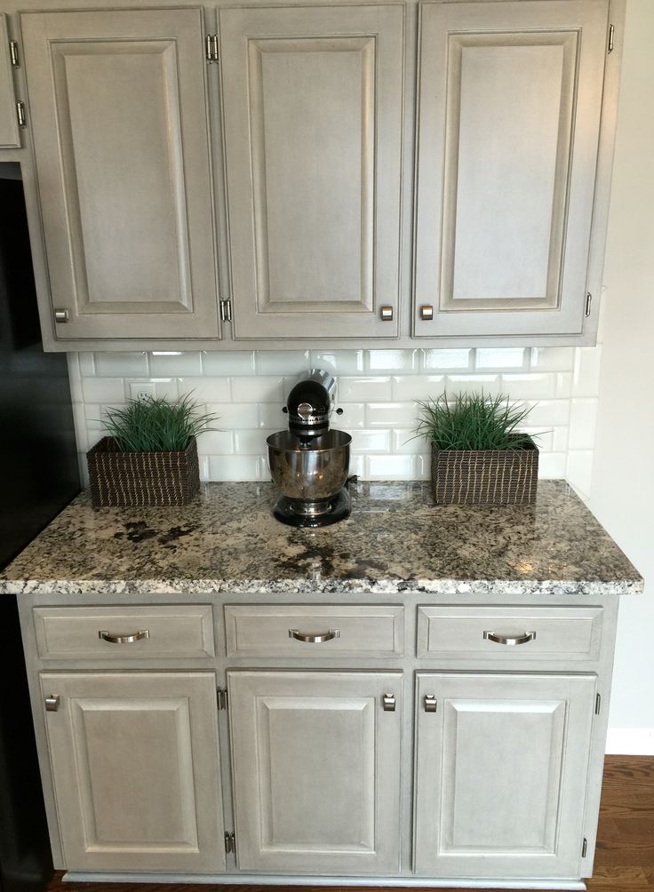 a kitchen with white cabinets and granite counter tops