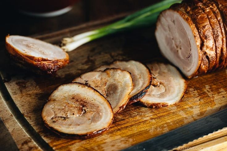 sliced meat on a cutting board with knife