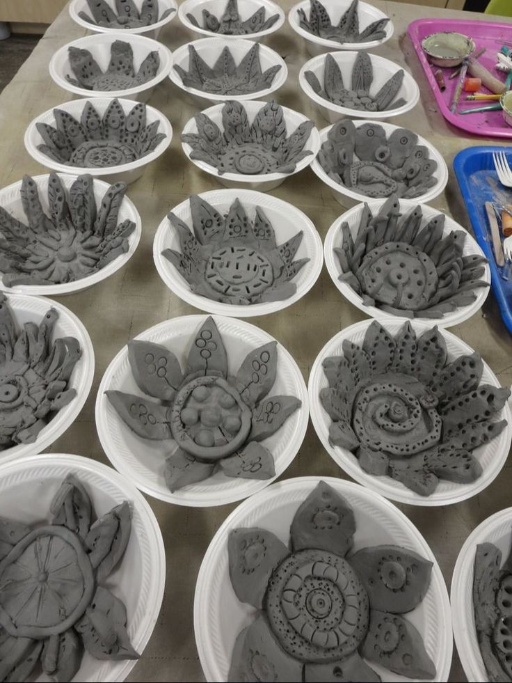 many bowls with designs on them sitting on a table