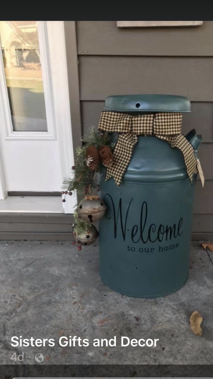 a large blue jar with a welcome sign on the side of it sitting in front of a door