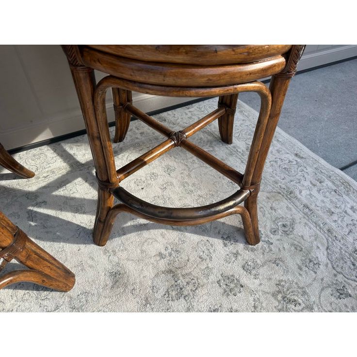 two wooden stools sitting next to each other on a carpeted floor in front of a door