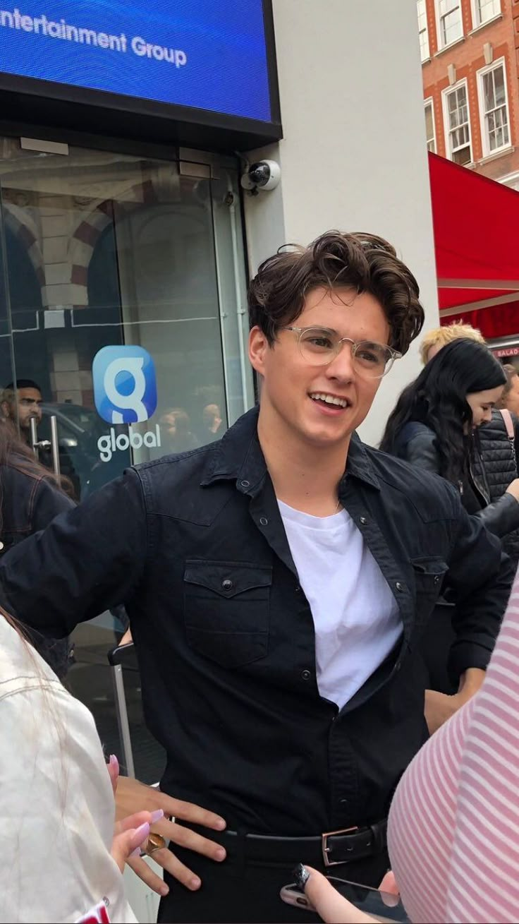 a man standing in front of a store with his hands on his hips and smiling