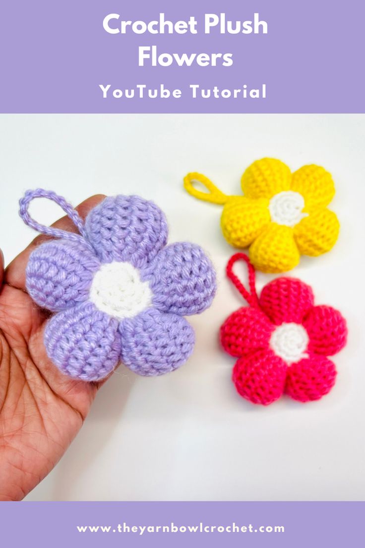 two crochet flowers are being held by someone's hand