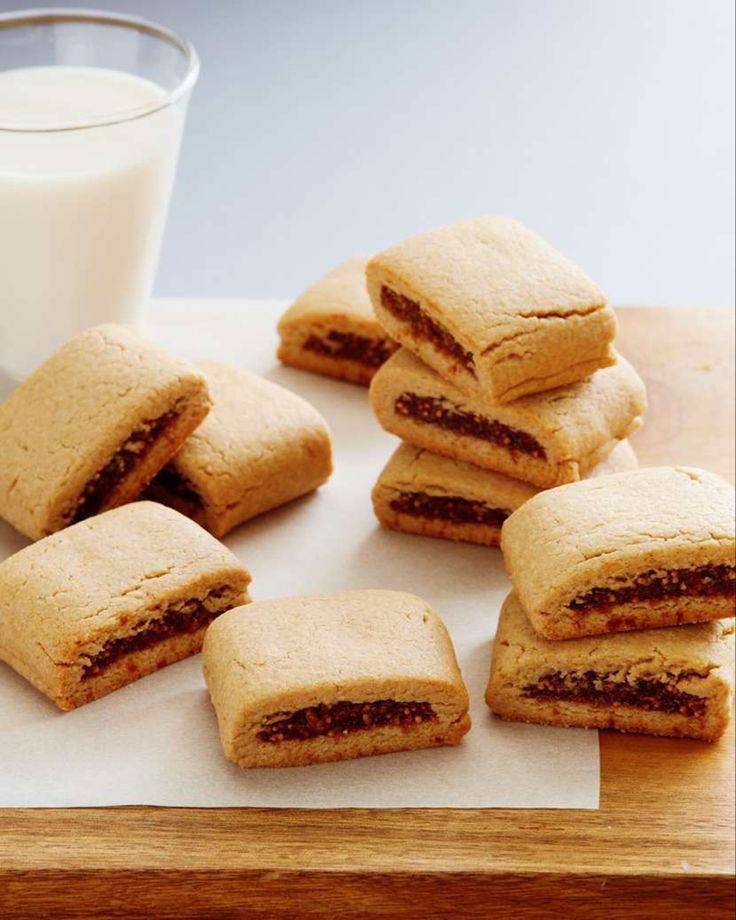 a bunch of cookies sitting on top of a cutting board next to a glass of milk