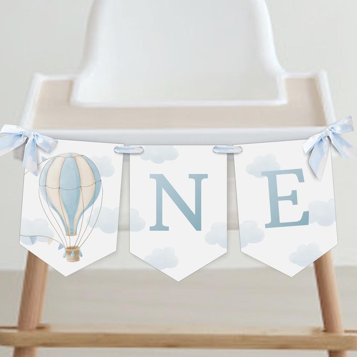 a baby's first birthday banner with hot air balloons and the word n e