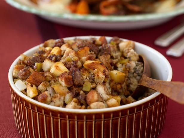 a bowl filled with stuffing next to a plate full of food