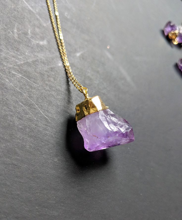 Raw amethyst is a classic in the world of gemstones. It is one of the more affordable stones with the most vibrant natural spectrum of purple tones. I have this necklace in both tiny crystals and large crystals, and a few different chain lengths 💟 **This listing is for only one necklace Each large crystal pendant measures approximately 1 inch in length.💜 Each small amethyst measures between 1/4 and 1/2 inch in length 💜 The chain for ThIs necklace measures 18 inches in length. You can purchase Lavender Amethyst Necklace With Stones, Spiritual Amethyst Crystal Necklace With Raw Stone, Amethyst Stone Necklaces For Gifts, Faceted Amethyst Healing Necklace, Purple Amethyst Pendant Crystal Necklace, Purple Amethyst Necklace With Natural Stones, Amethyst Stone Necklace For Gift, Amethyst Raw Stone Necklace For Healing, Purple Mineral Crystal For Jewelry Making