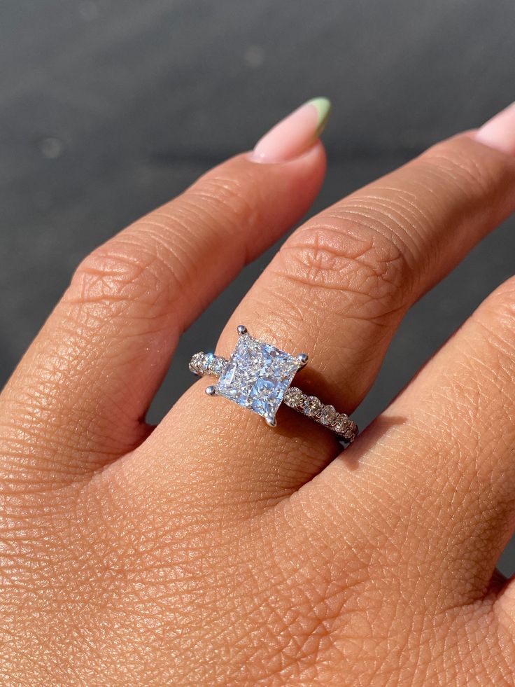 a woman's hand with a diamond ring on it