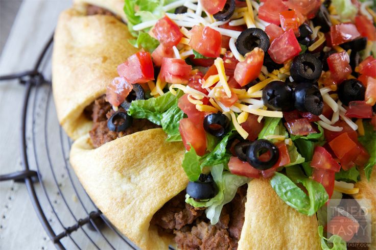 a taco salad with lettuce, black olives and cheese on top