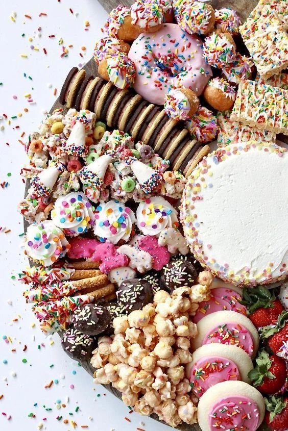 a platter filled with lots of different types of donuts and sprinkles