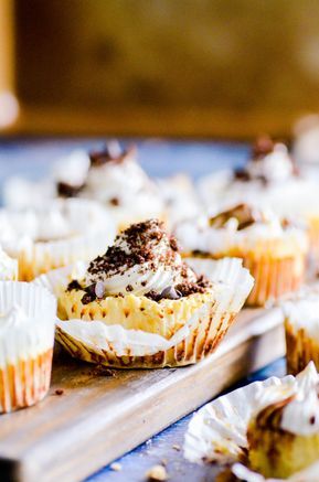 several cupcakes with white frosting and chocolate toppings