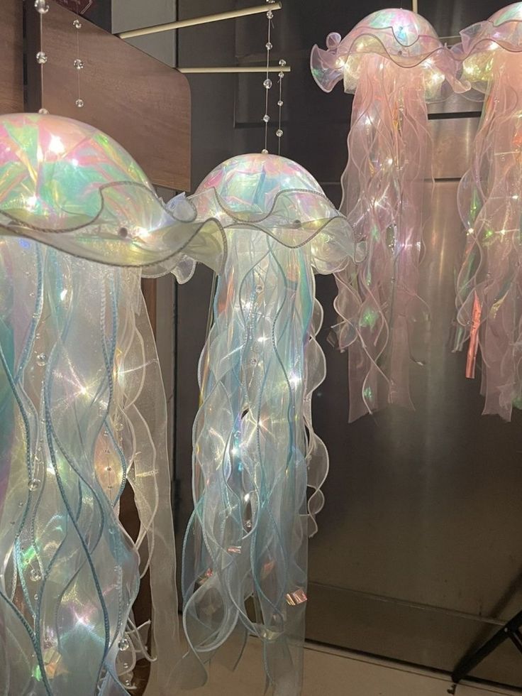 two jellyfish lights hanging from strings in front of a mirror