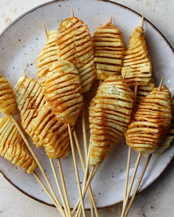 some food is sitting on a plate with toothpicks in it's middle