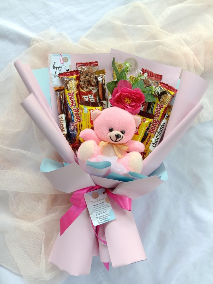 a pink teddy bear with candy, candies and chocolates in it's wrapper