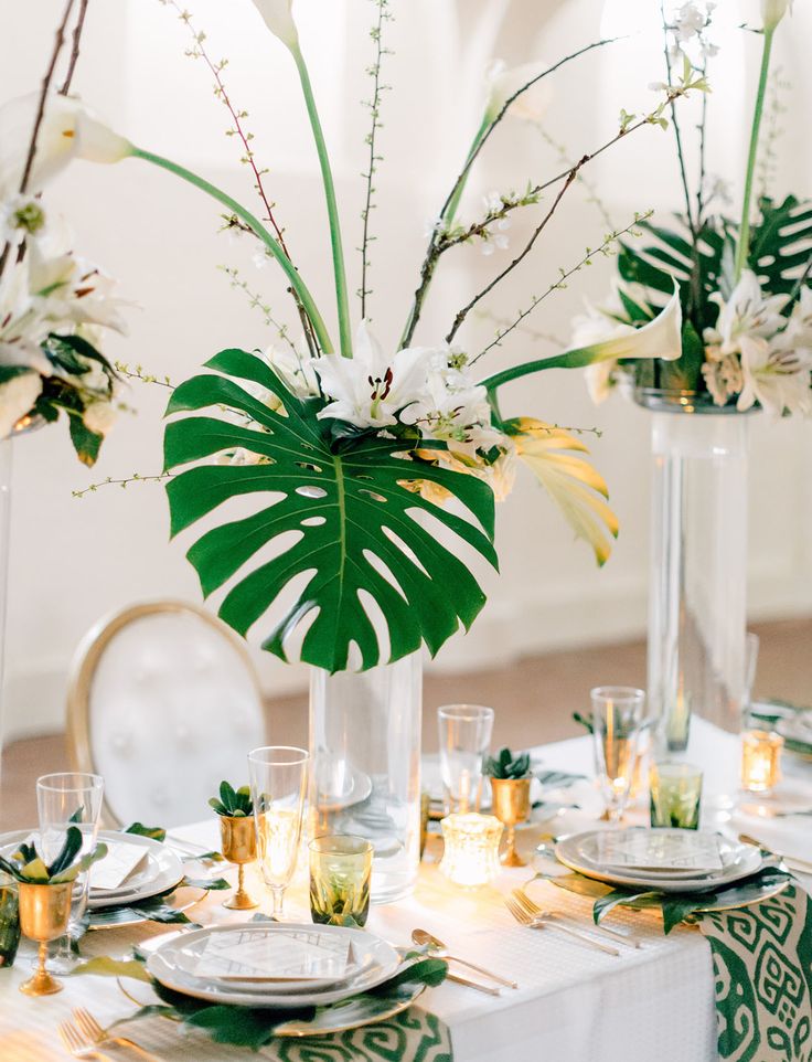 the table is set with white and green flowers