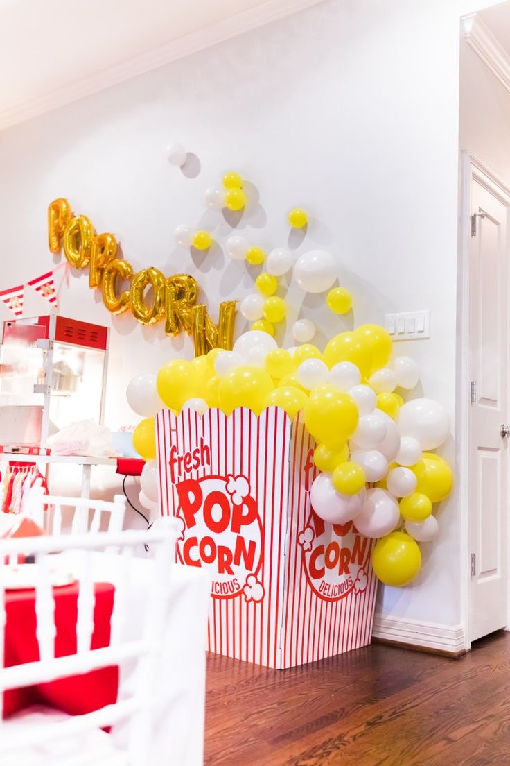 popcorn buckets filled with yellow and white balloons