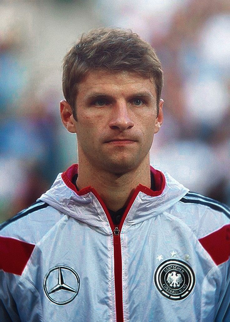 a close up of a person wearing a jacket with a soccer ball in the background