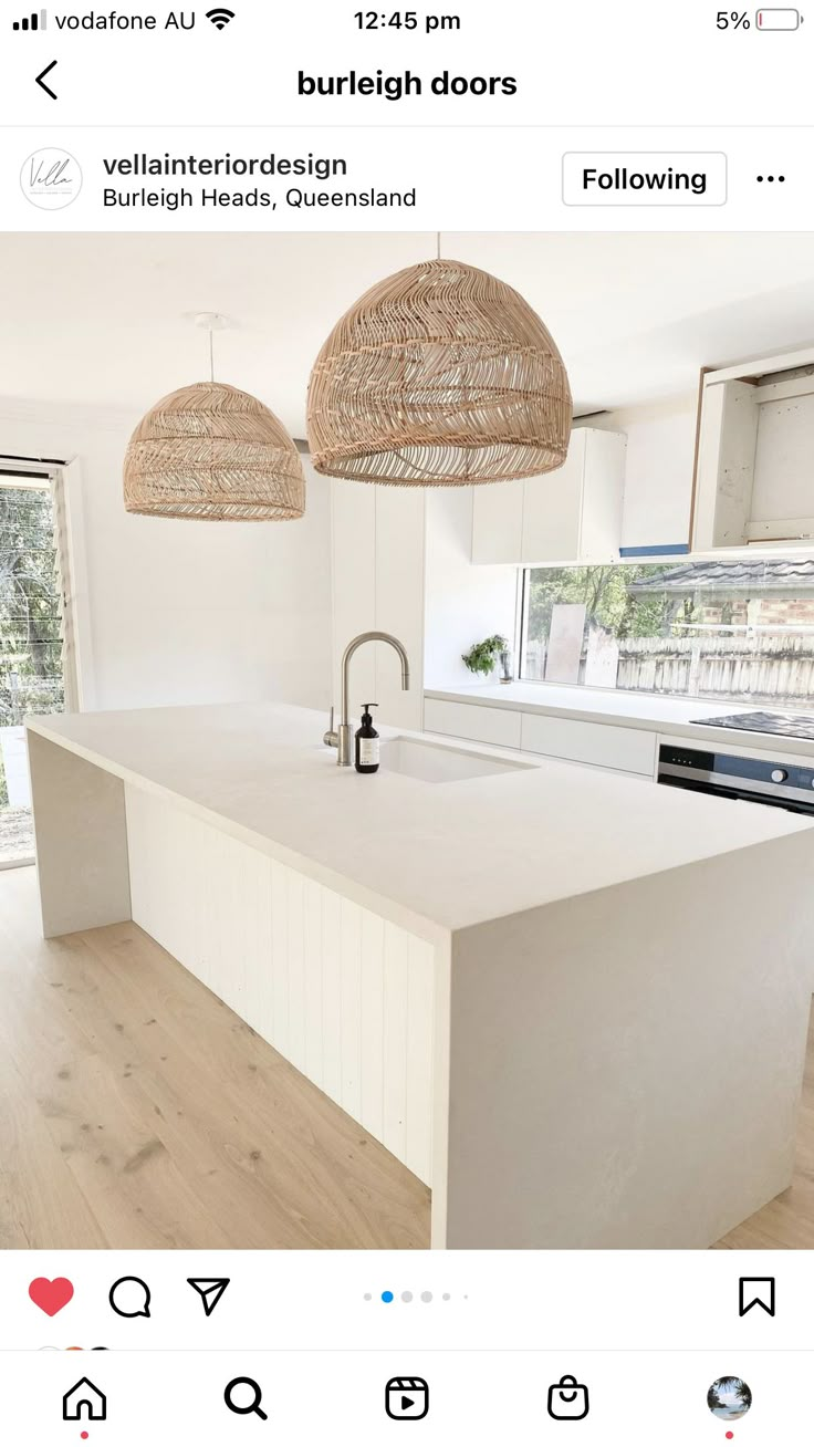 an instagramted photo of a kitchen with two pendant lights above the island counter