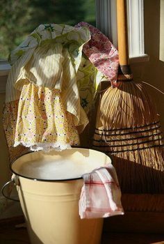 an umbrella is sitting on the window sill next to a bucket and other items