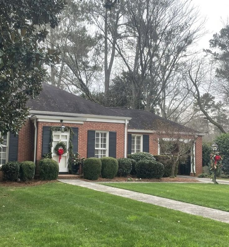 a red brick house with wreaths on the front door