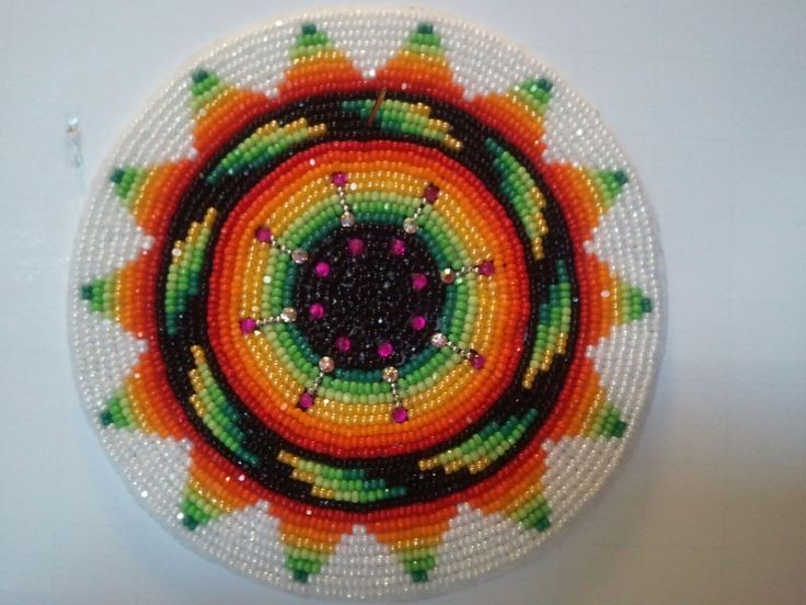 a beaded brooch with an orange and green design