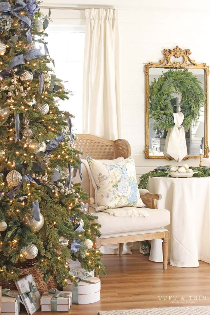 a decorated christmas tree in a living room with blue and white ornaments on the branches