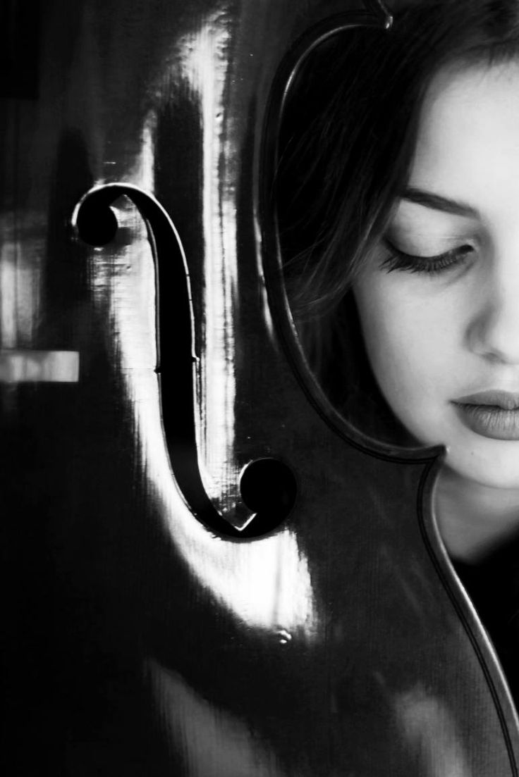 a woman with her eyes closed is looking at the camera while holding an instrument in front of her face