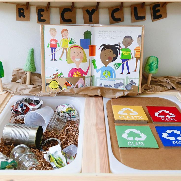 an open cardboard box filled with children's toys and paper on top of a table