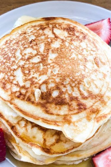 pancakes with syrup and strawberries on a plate