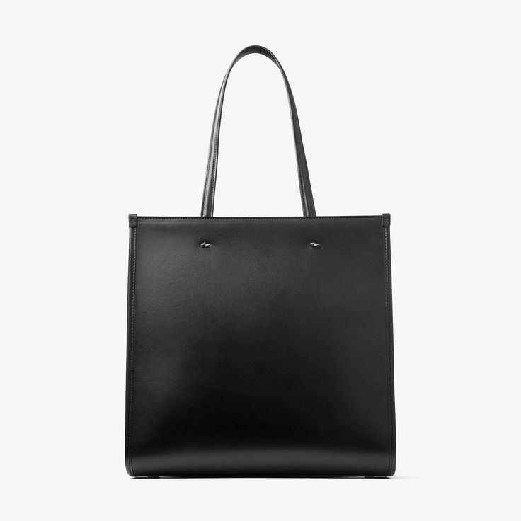 Our N/S Tote provides a departure from the classic tote bags in smooth leather. Our signature Jimmy Choo logo brings a touch of distinction to this versatile style that features a long detachable shoulder strap to be worn long or across the body. Practical and functional; it's comfortable to carry with easy interior access. Sleek Everyday Bag With Top Handle, Sleek Top Handle Bag For Everyday, Sleek Square Business Bag, Classic Shoulder Bag For Shopping, Sleek Calf Leather Shoulder Bag For Everyday Use, Top Handle Satchel With Smooth Grain For Shopping, Top Handle Smooth Grain Satchel For Shopping, Chic Square Bag With Smooth Grain, Sleek Shoulder Bag With Top Handle And Smooth Grain