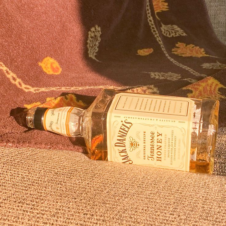 an empty bottle sitting on top of a couch