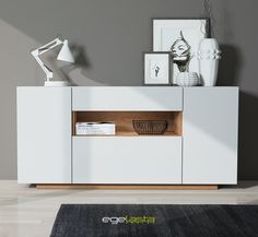 the sideboard is white and has a wooden shelf